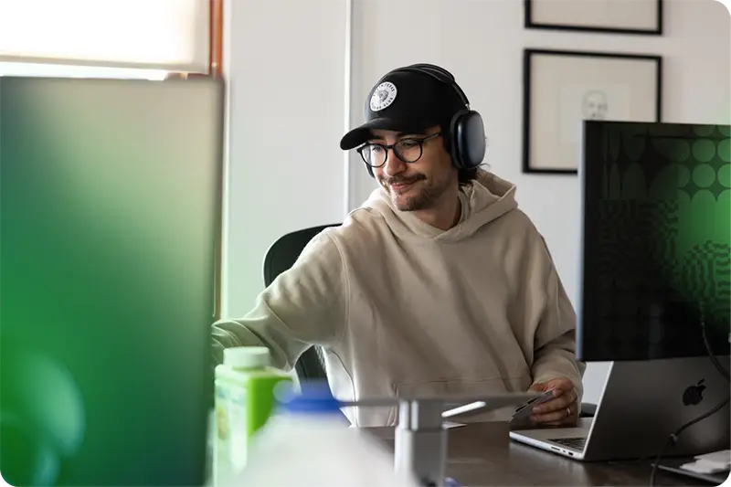 Man sitting at desk wearing headphones.