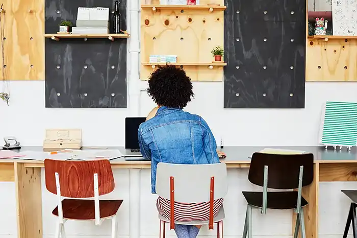 一名女士背对着,正在笔记本电脑上工作