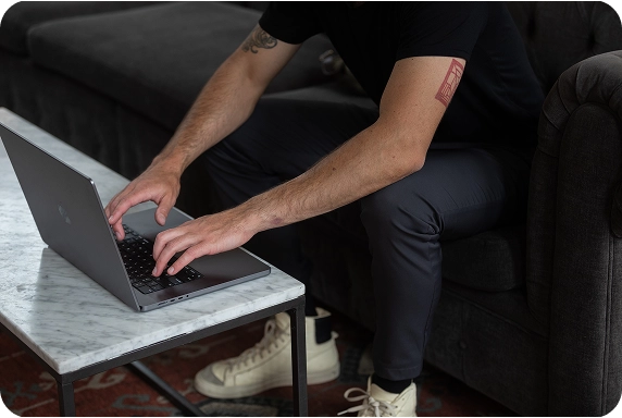 Woman seen with her back turned, working on her laptop