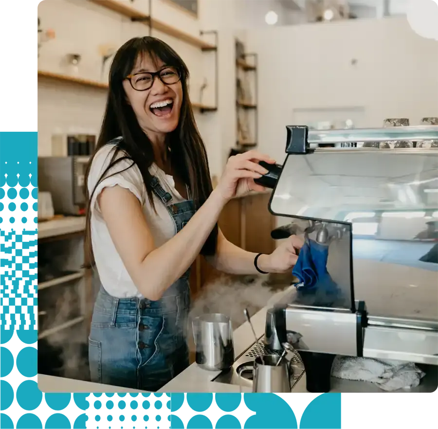 Female barista smiling while she makes coffee because she loves her job